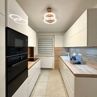 Contemporary kitchen design featuring white cabinetry, wooden countertops, and modern appliances for.