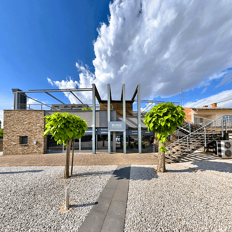Modern furniture store facade with outdoor seating area in Murska Sobota.