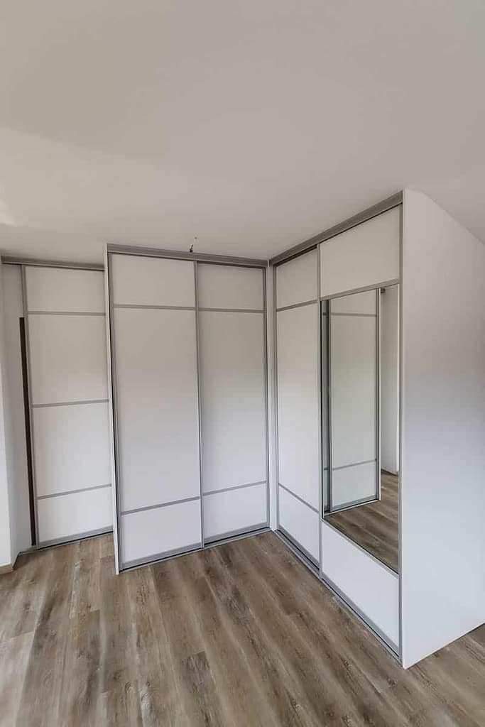 Custom bedroom wardrobe with sliding doors and mirror for a modern bedroom.