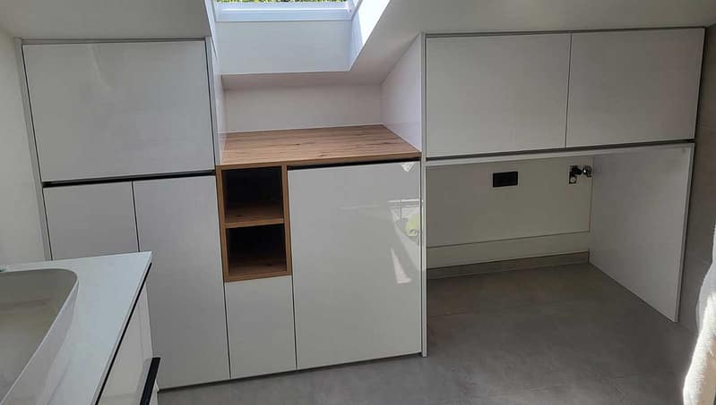 Modern bathroom cabinetry with wooden countertop and storage solutions.
