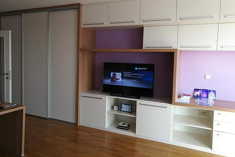 Modern living room with custom-made furniture and integrated TV setup for a cozy atmosphere.