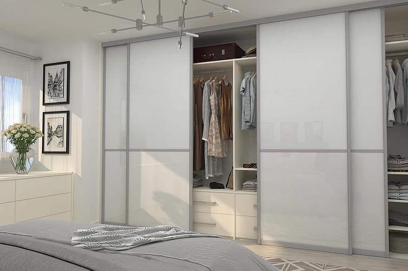 Built-in wardrobe with sliding doors for organized storage in bedroom.