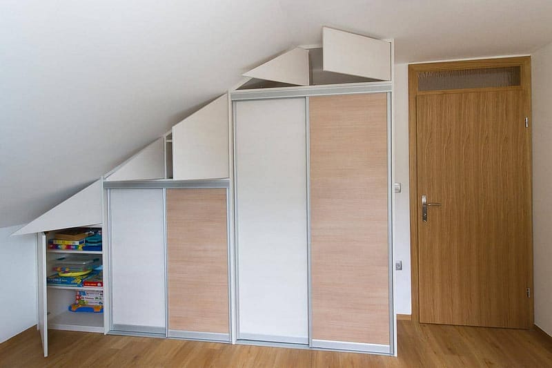 Custom built-in wardrobe with sliding doors for attic storage.