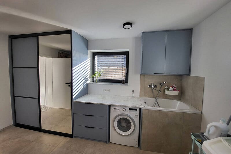 Custom bathroom cabinetry with washing machine and storage solutions.