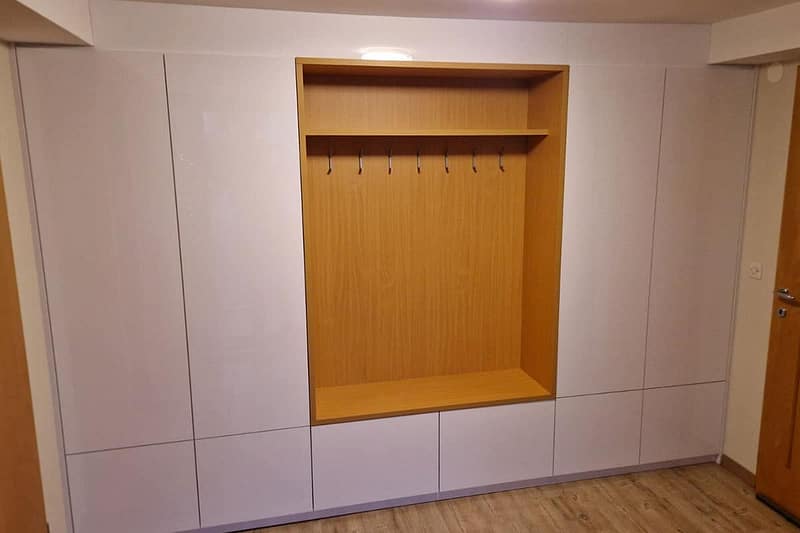 Custom-made entryway furniture with hooks and storage.